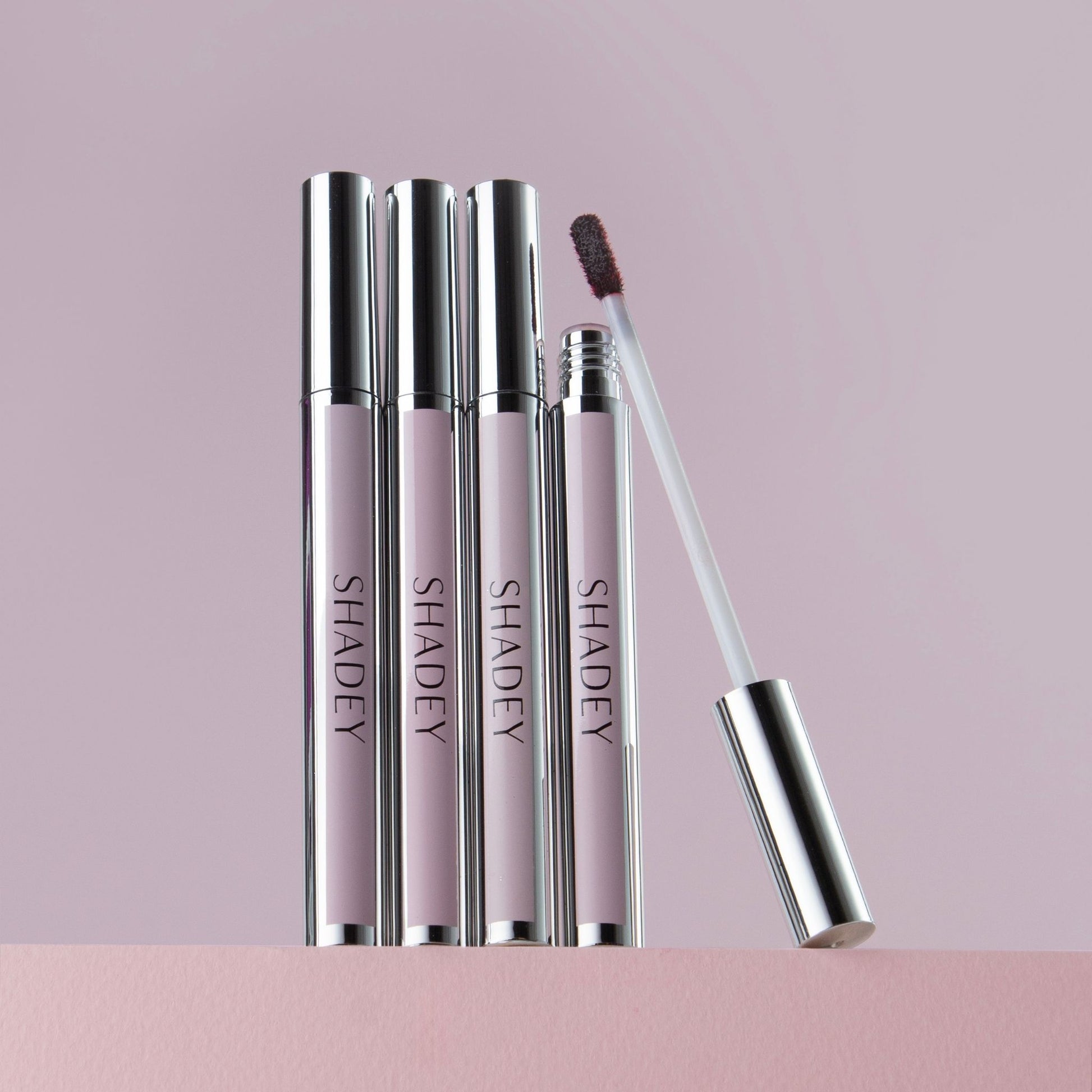 Set of 'SHADEY' lip products on a pink background