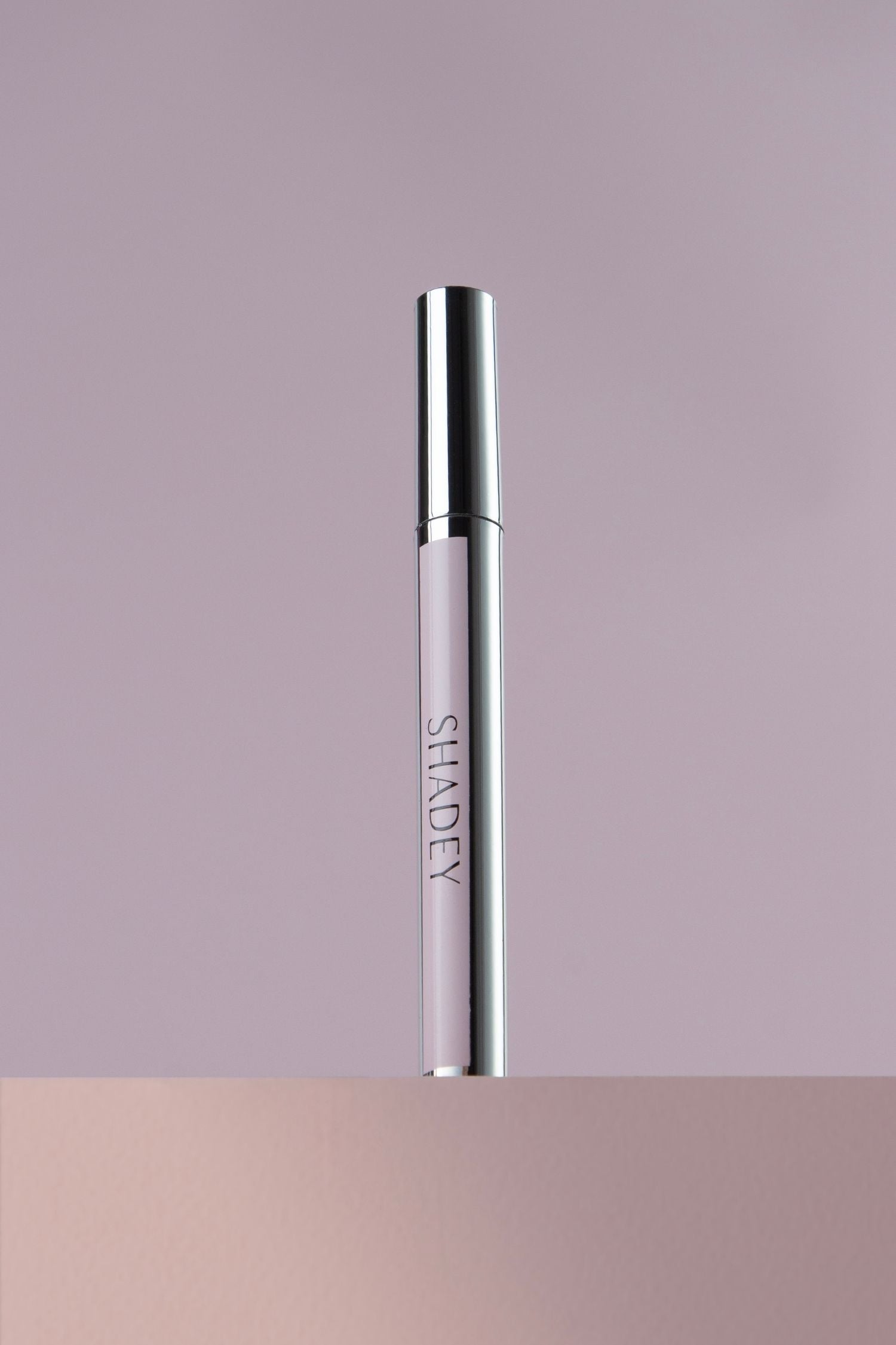 Silver cylindrical product with 'SHADEY' branding on a gradient background